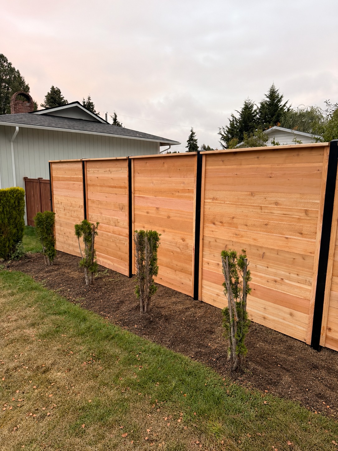 Horizontal cedar fencing on black metal posts